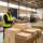 Almacén de distribución alimentaria con palés de productos navideños y un operario con lector