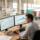 Planificador analizando gráficos de previsión de ventas con un almacén al fondo